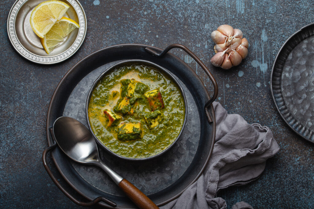 spinach and paneer curry on a dark background