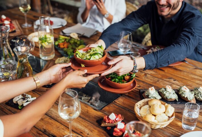 People at restaurant table being served food
